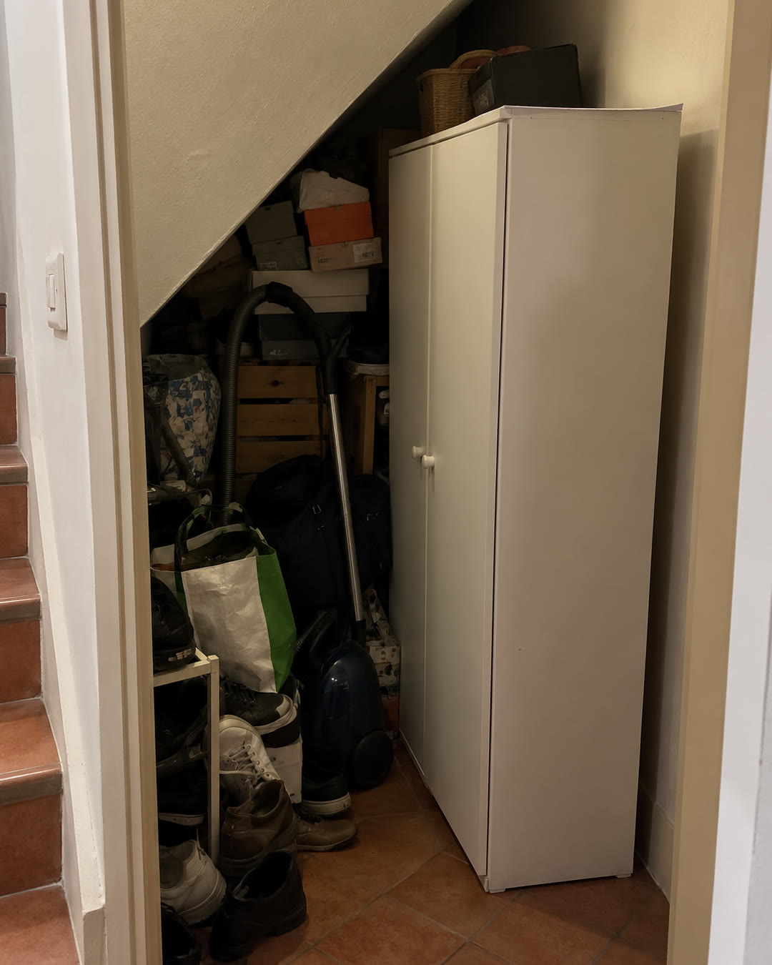 Un sottoscala pieno di scatole, con un mobile in kit che non segue la scala